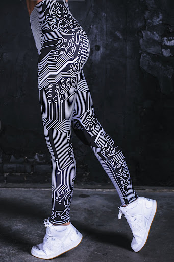 black and white patterned funky leggings with white sneakers on a young woman