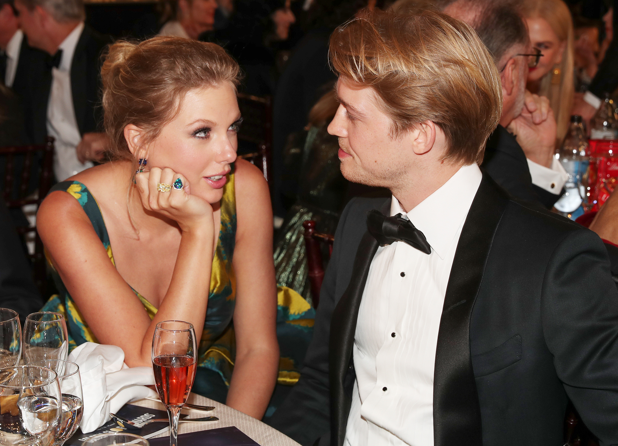 Taylor Swift and Joe Alwyn having a conversation at an event.