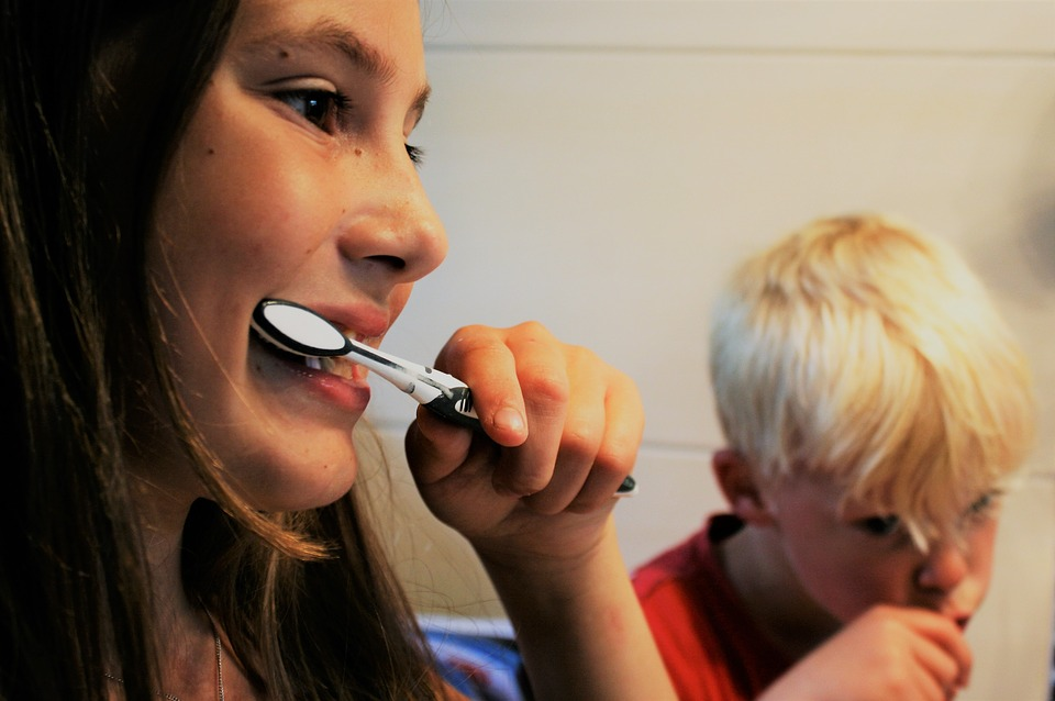 two young children brushing their teeth