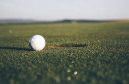 a golf course close u on a golf ball and putter