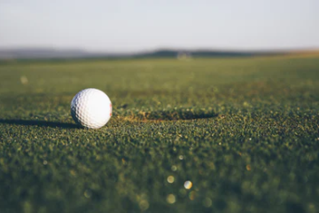 a golf course close u on a golf ball and putter