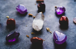 meditation and healing crystals in pink, pruple, and tigers eye or orange