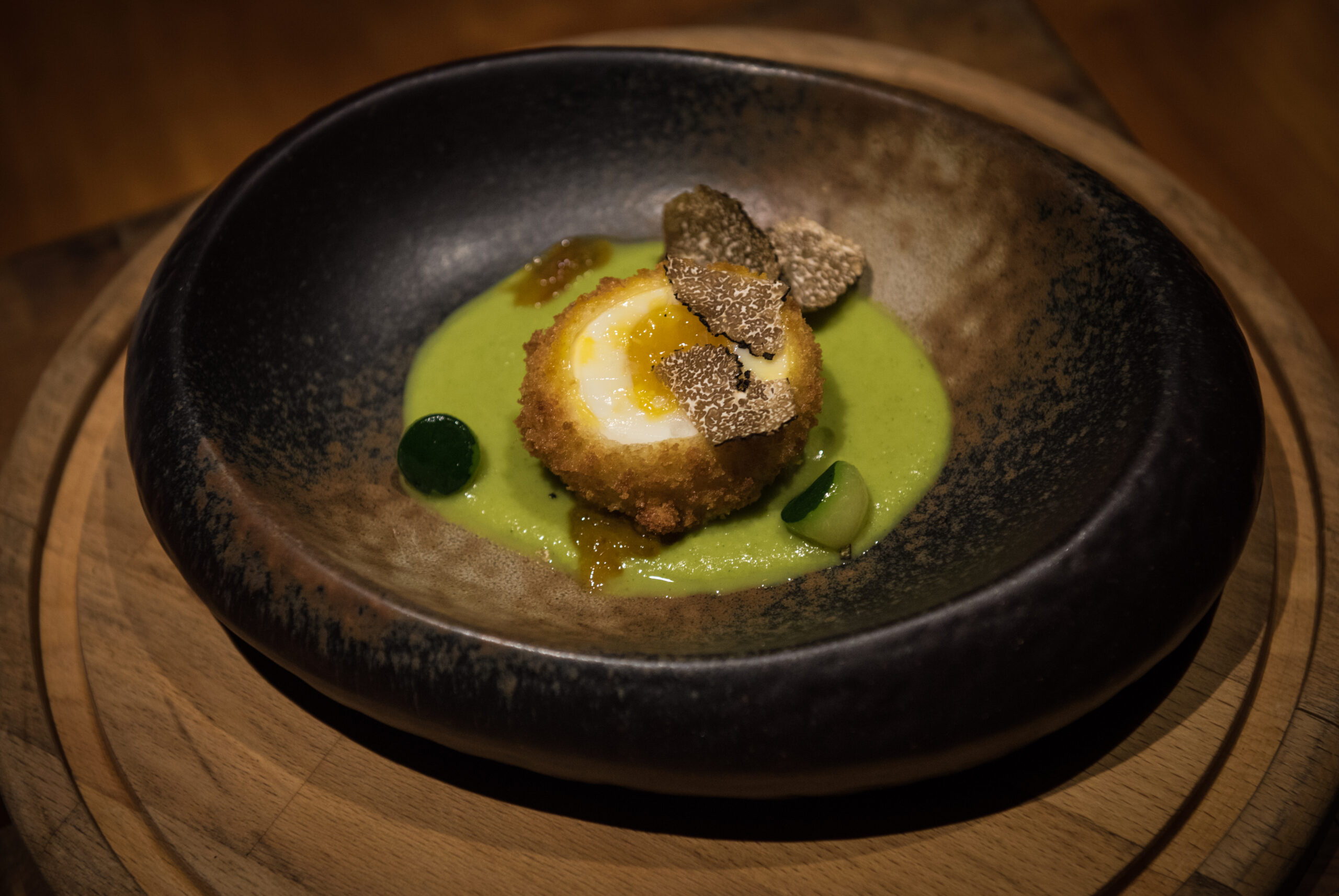 Deep fried egg with a beautiful truffle and aesthetically pleasing green sauce at ritz carlton fine dining