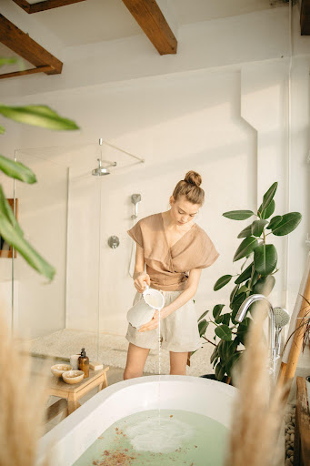 a woman in a white ensemble aesthetic bathroom with plants