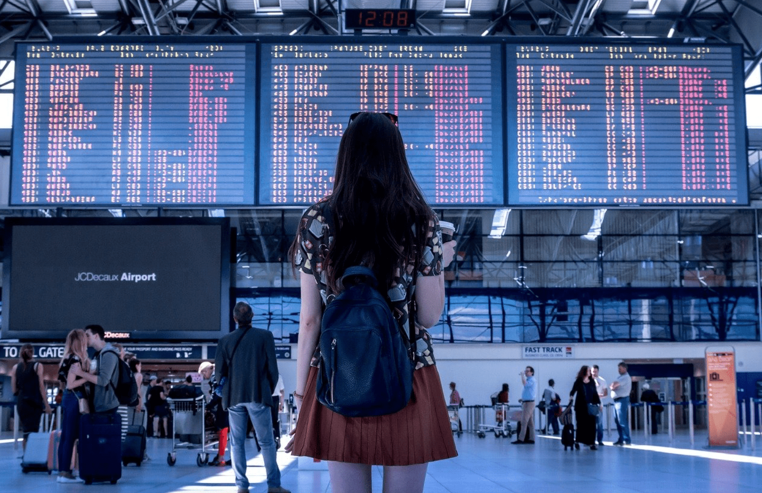 woman in airport looking at departures and arrivals