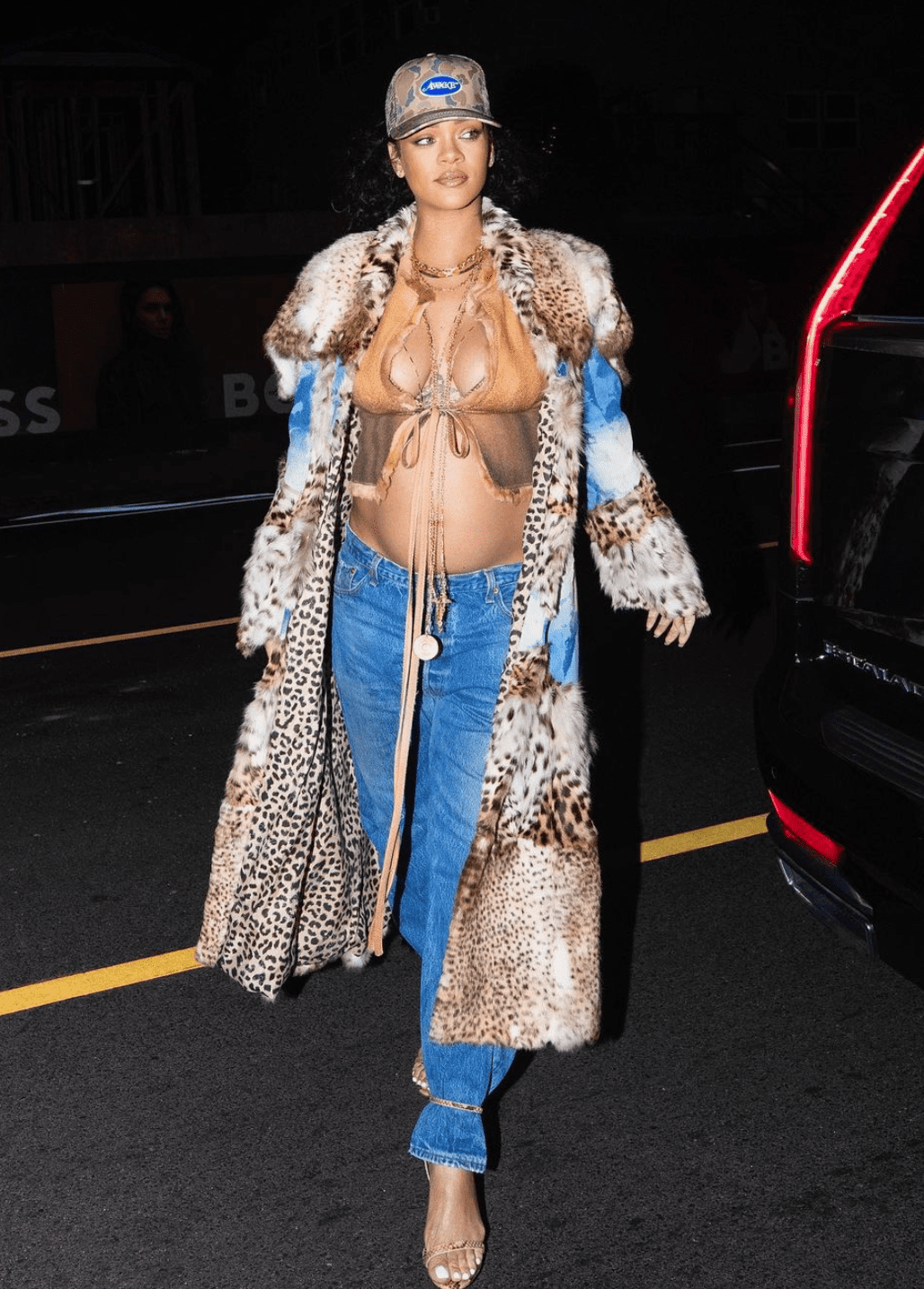 Rihanna in a Y2K ensemble with a butterfly top, jeans, and a patchwork denim and leopard print coat