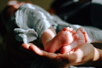 Parent holding infant's feet