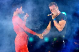 Rihanna in bright red dress and Chris Martin in black T-shirt