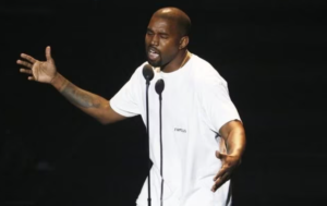 Kanye in a white shirt on stage