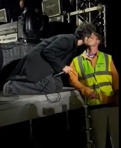 Matty Healy kissing a guard.