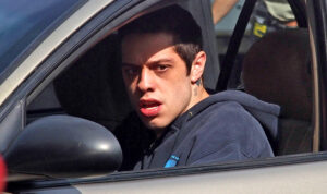 Pete Davidson in a car looking distraught out of the window.