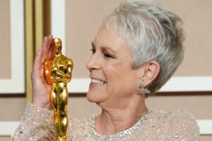 Jamie Lee Curtis smiling at her Oscar at the after show red carpet.