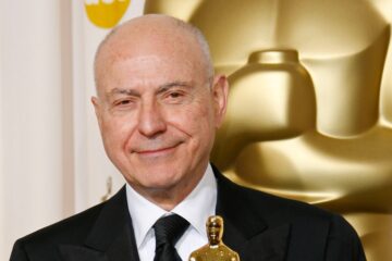 Alan Arkin poses with the Oscar he won for best supporting actor for his work in 'Little Miss Sunshine'. He is wearing a black suit, black tie and a white shirt.