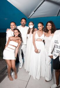 Jennifer Lopez and Ben Affleck posing for a photo outside at Michael Rubin's Fourth of July White Party with other guests.