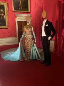 A photo of the Kensington Palace exhibit of Blake Lively's dress (left) next to Ryan Reynolds' suit (right) that they wore 2022 Met Gala