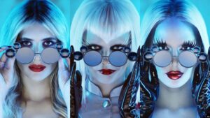 Screenshots of each actress in the AHS promo stitched together vertically. They are each holding Windsor glasses on the bridge of their nose. From left to right Emma Roberts, Cara Delevingne and Kim Kardashian