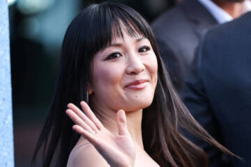 Constance Wu waving over her shoulder to fans on a red carpet for 'The Terminal List'