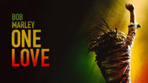 Official poster for 'Bob Marley: One Love'. It shows the back of Bob Marley singing with his fist in the air.