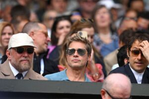 From left to right: Guy Ritchie, Brad Pitt, and Jeremy Kleiner sitting next to each other in the audience at Wimbledon 2023.