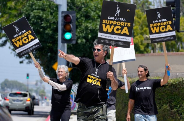 SAG and WGA members outside on strike protesting unfair payments.