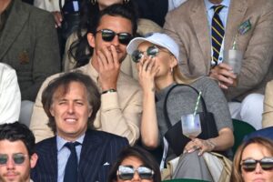 Jonathan Bailey (left) and Ariana Grande (right) sitting next to each other in the audience at Wimbledon.