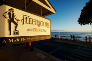 A sunset photo of the sign outside of Mick Fleetwood's restaurant in Maui reading: "Fleetwood's on Front st. A Mick Fleetwood Restaurant and Bar"