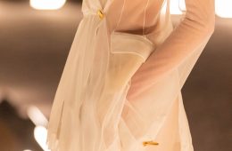 A sheer ivory Schiaparelli suit from the Spring/Summer 2026 runway, featuring a translucent tailored jacket with gold hardware and soft, fluid draping.