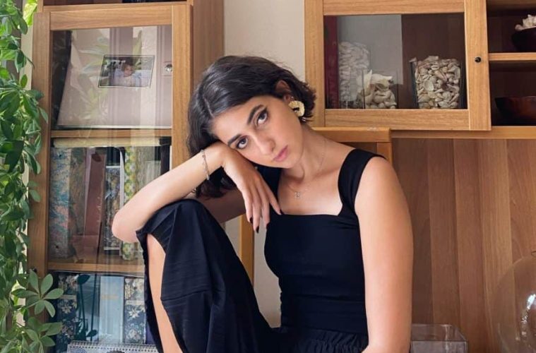 Rama Duwaji poses in her home in a fashion forward black dress