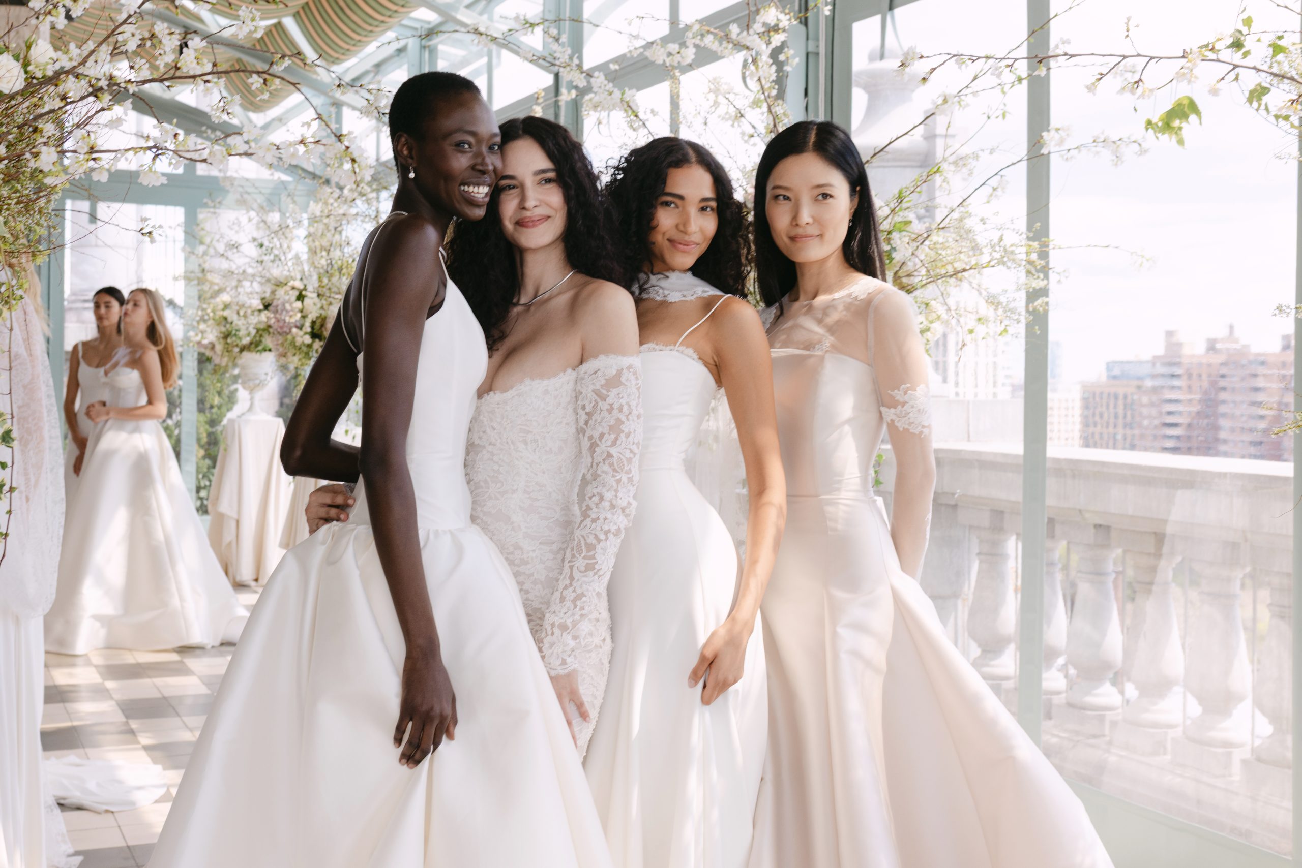 Models at the Sarah Seven Presentation for Bridal Fashion Week. Standing together in a bright terrace in bridal gowns