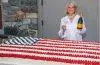 Martha Stewart poses beside a giant American flag cake created for her Founding Father-themed celebration honoring America's 250th anniversary.