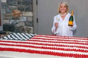 Martha Stewart poses beside a giant American flag cake created for her Founding Father-themed celebration honoring America's 250th anniversary.