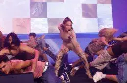 Jennifer Lopez wearing a nude illusion catsuit featuring realistic tattoo-inspired artwork during a public appearance.