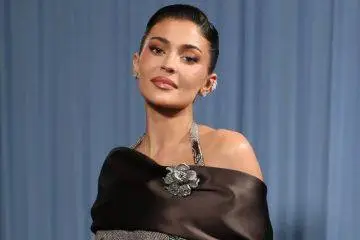 Kylie Jenner poses at a public event wearing a stylish designer outfit, highlighting her signature beauty and fashion aesthetic.