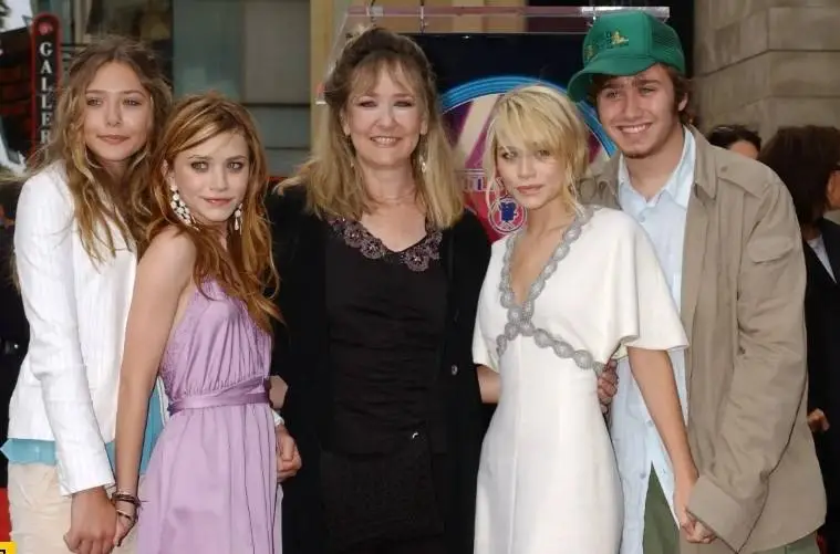 Mary-Kate and Ashley Olsen pose with family members at their brother Trent Olsen's wedding celebration.
