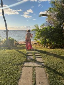 Halle Berry walking along a tropical beach in a pink floral cover-up during her latest Instagram post.