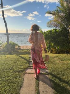 Halle Berry walking along a tropical beach in a pink floral cover-up during her latest Instagram post.