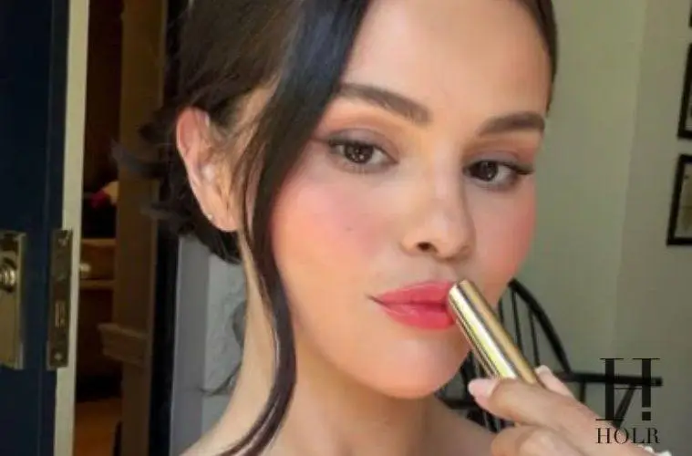 Selena Gomez applying Rare Beauty's new Soft Pinch Lip Oil Stick before its official launch.