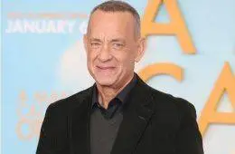 Tom Hanks smiles while attending a Hollywood premiere celebrating his decades-long acting career.