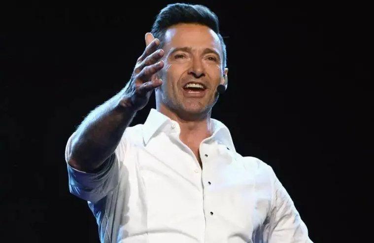 Hugh Jackman smiles while attending a Hollywood red carpet event celebrating his acting career.