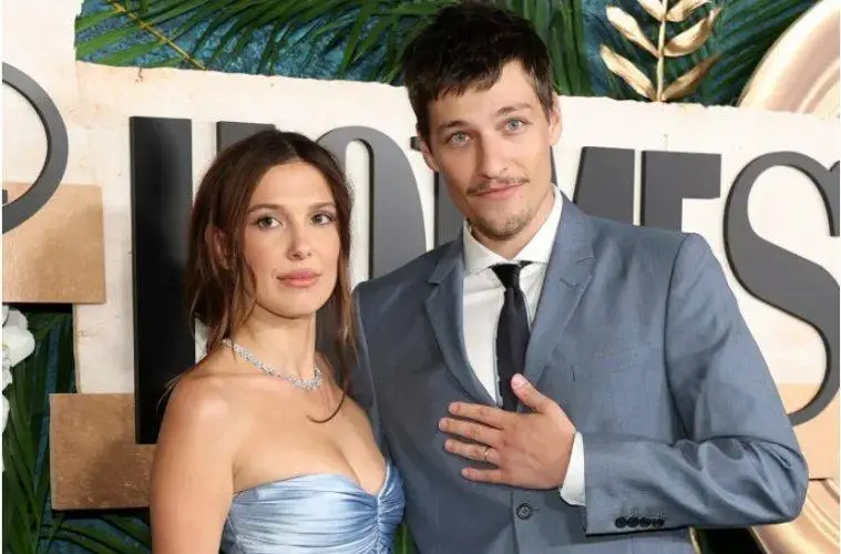 Millie Bobby Brown smiles during a promotional event while discussing motherhood and her acting career.