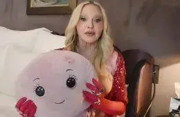 Madonna smiles while holding Octavia, the stuffed octopus she says reminds her of the nurse who cared for her during her recovery from a life-threatening illness.