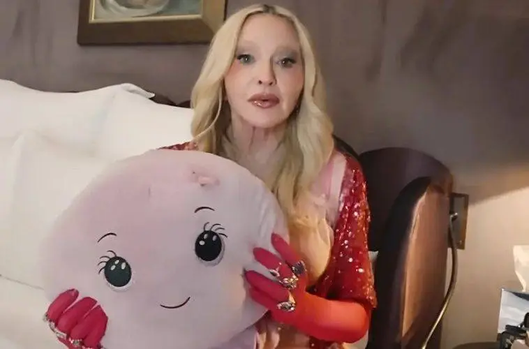 Madonna smiles while holding Octavia, the stuffed octopus she says reminds her of the nurse who cared for her during her recovery from a life-threatening illness.