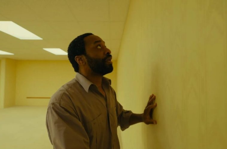 A haunting scene from A24's Backrooms featuring the film's signature endless yellow hallways now available to watch at home.