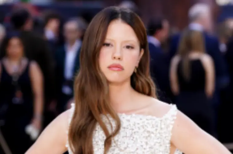 Mia Goth poses on the red carpet at The Odyssey premiere, wearing an elegant designer outfit during the star-studded event.