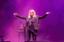 Bonnie Tyler performing on stage during a live concert, celebrating the legendary singer's decades-long career and lasting musical legacy.