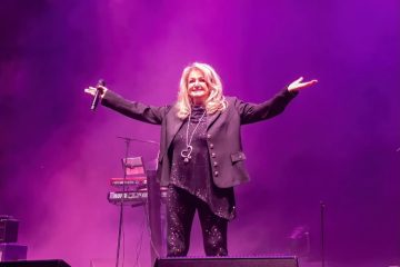 Bonnie Tyler performing on stage during a live concert, celebrating the legendary singer's decades-long career and lasting musical legacy.