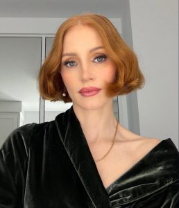 Jessica Chastain showcasing her jaw-grazing copper bob hairstyle during Taylor Swift's wedding weekend, highlighting one of the season's biggest celebrity hair transformations.