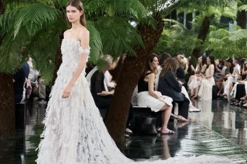 Model wearing Dior Fall/Winter 2026–2027 Haute Couture Look 57, featuring a white silk chiffon ensemble embroidered with cactus flowers and finished with artistic frayed edges.