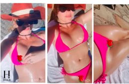 Britney Spears relaxes poolside in a bright pink bikini while covering one nipple with a rose emoji in a new Instagram video.