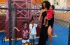 Rihanna stands with her children outside her childhood neighborhood on Rihanna Drive in Barbados.